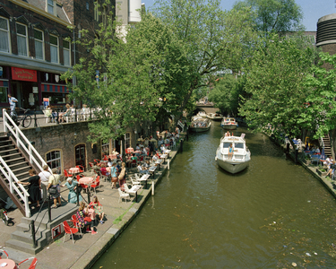 805782 Gezicht op de Oudegracht te Utrecht met pleziervaart en links en rechts werfterrassen; op de achtergrond de Viebrug.